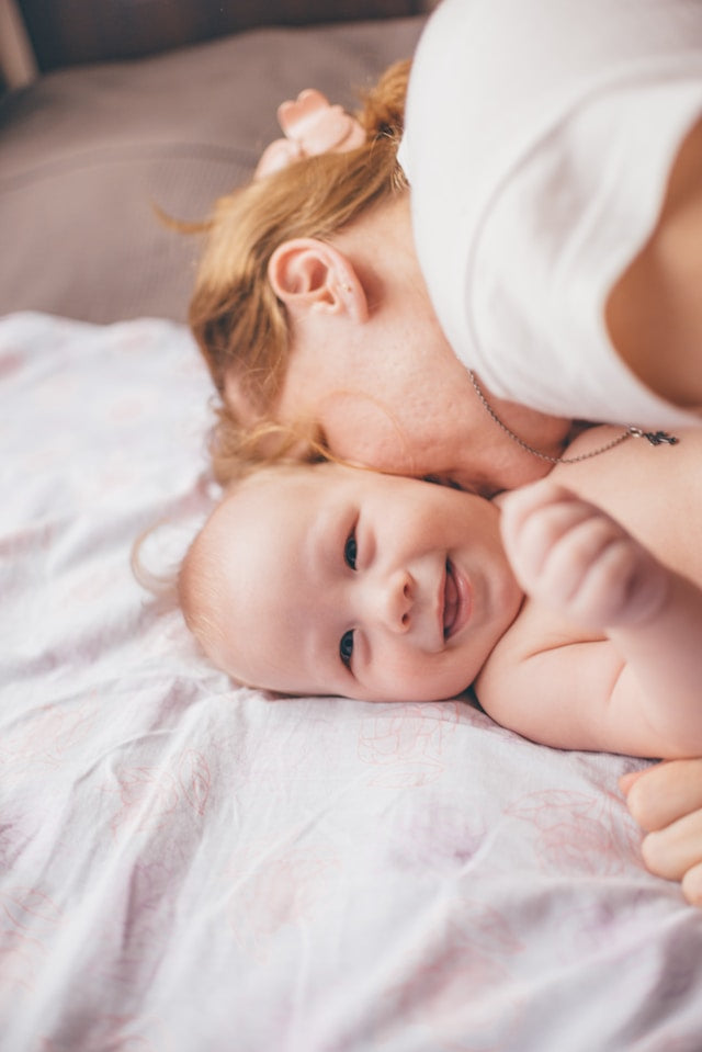 baby lying on bed mattress