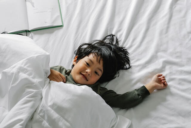 cute boy lying happily on a mattress