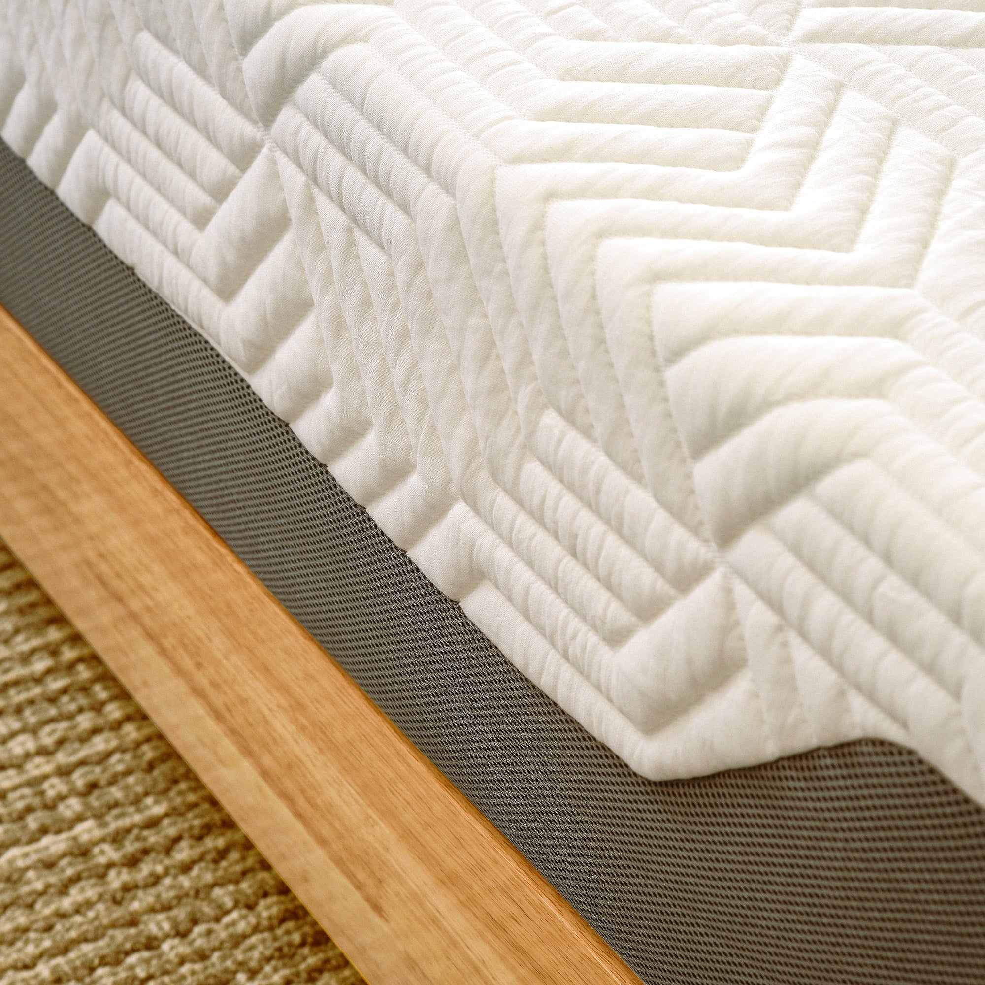 A close-up view of a Valmori Hybrid Mattress Ⅱ (Medium) with a textured white cover, and a gray side panel.